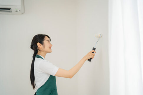壁を塗る女性